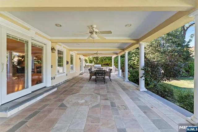 a view of a patio with a table and chairs next to a yard