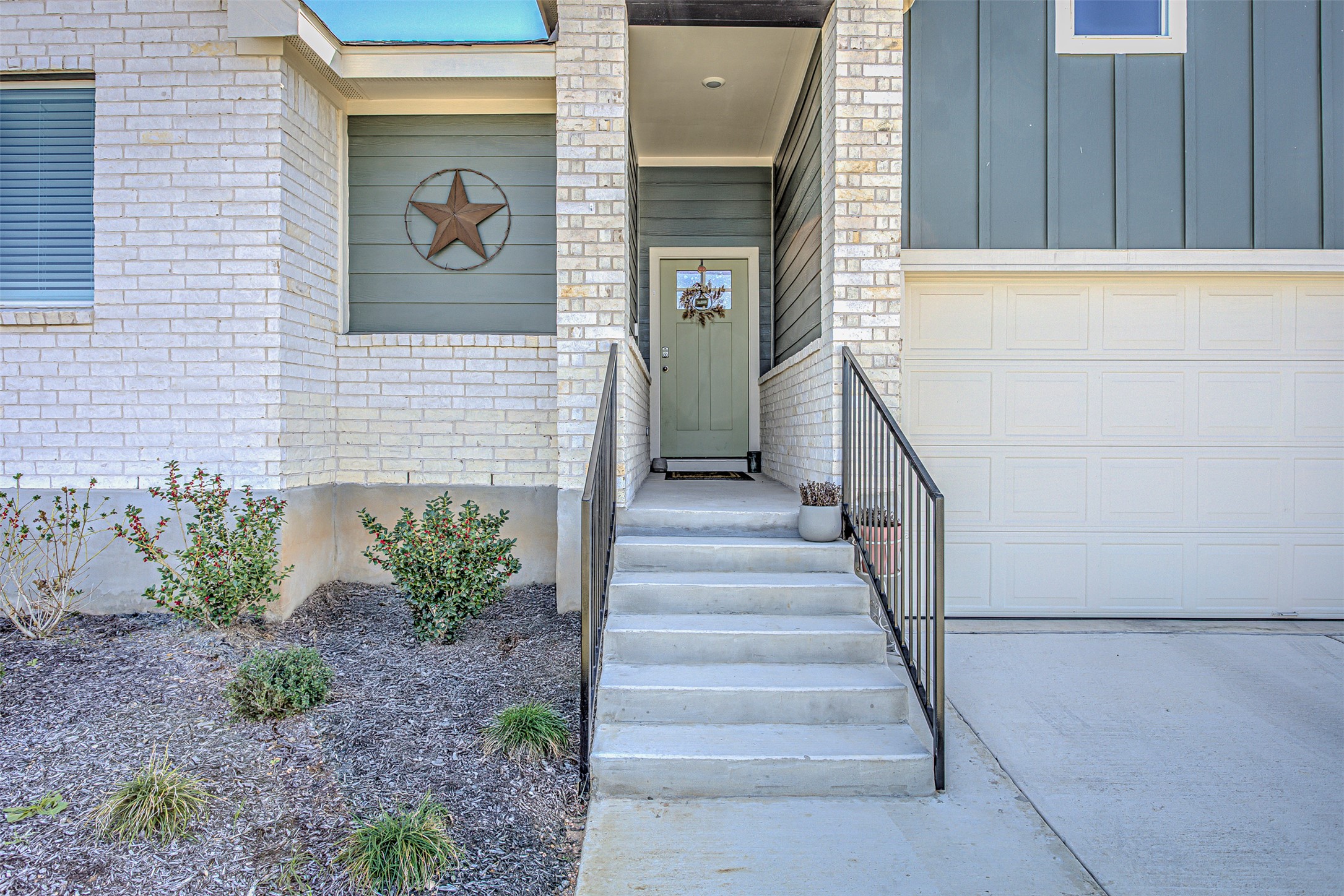 309 Lone Cedar Road Marble Falls, TX 78654 - Photo 2 of 35 Entrance to property featuring brick siding, board and batten siding, a garage, and concrete driveway