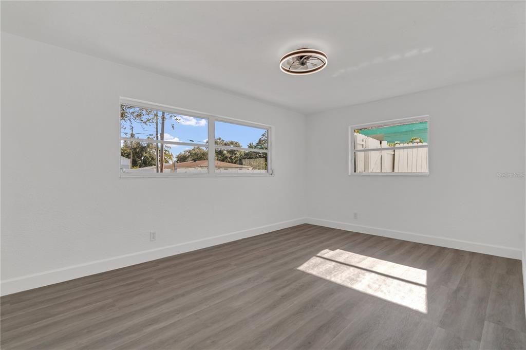 11598 Ridge Road Largo, FL 33778 - Photo 12 of 29 a view of empty room with wooden floor and fan