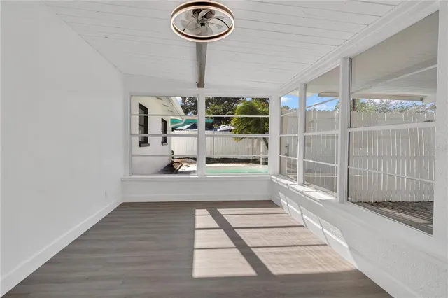 a view of empty room with wooden floor
