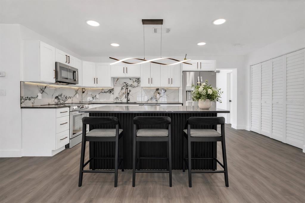 11598 Ridge Road Largo, FL 33778 - Photo 4 of 29 a kitchen with a dining table chairs and wooden floor