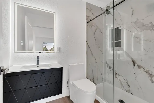 a bathroom with a sink a toilet and shower