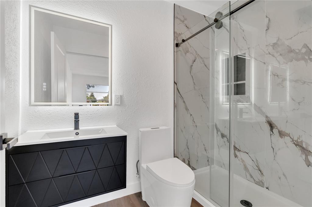 11598 Ridge Road Largo, FL 33778 - Photo 7 of 29 a bathroom with a sink a toilet and shower