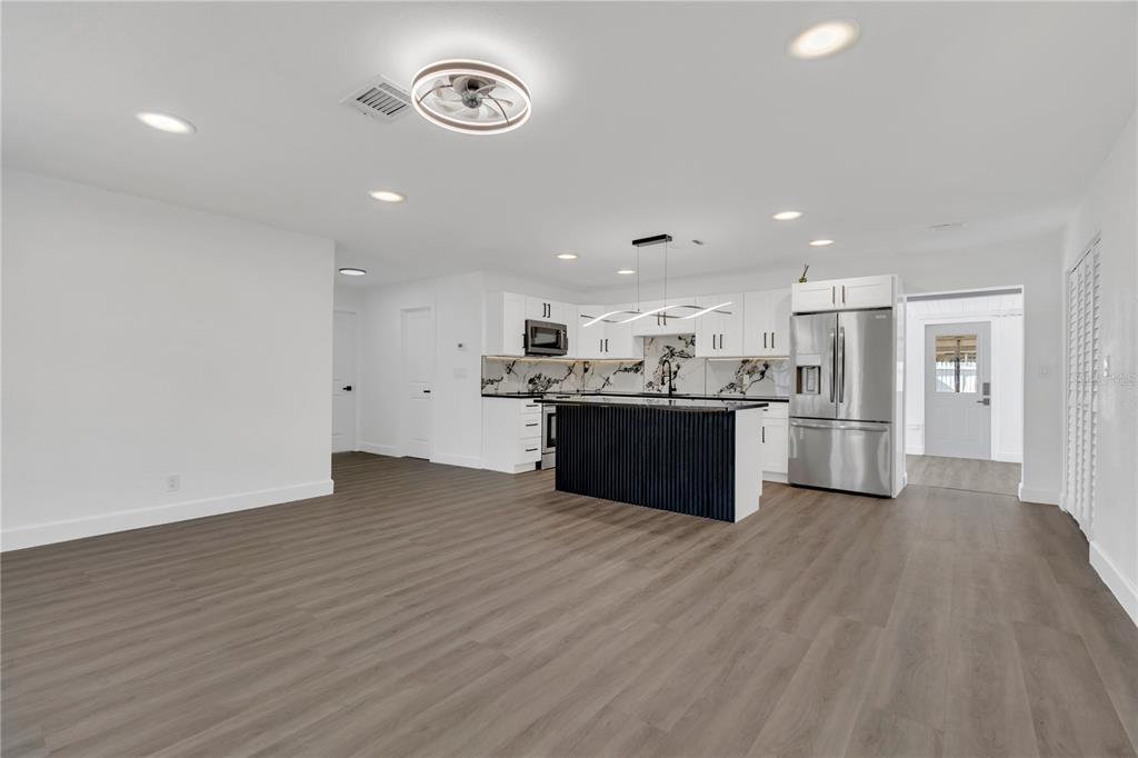 11598 Ridge Road Largo, FL 33778 - Photo 9 of 29 a large kitchen with stainless steel appliances granite countertop a large counter top and wooden floors