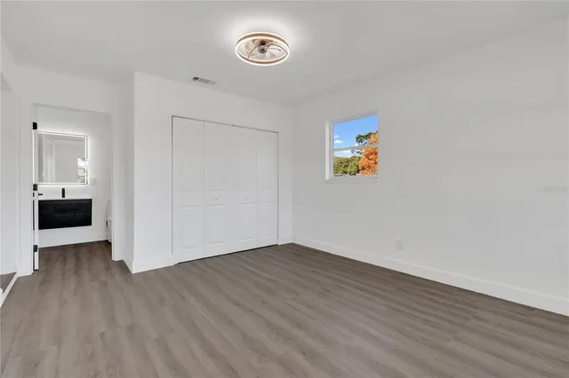 a view of empty room with wooden floor
