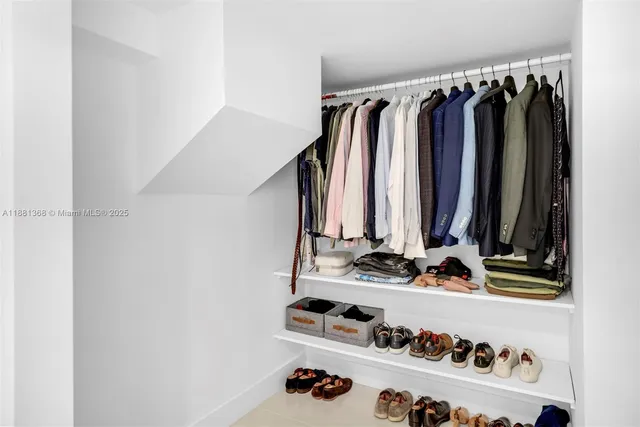a view of walk in closet with clothes and shoes