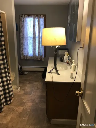 a bathroom with a sink toilet next to a window