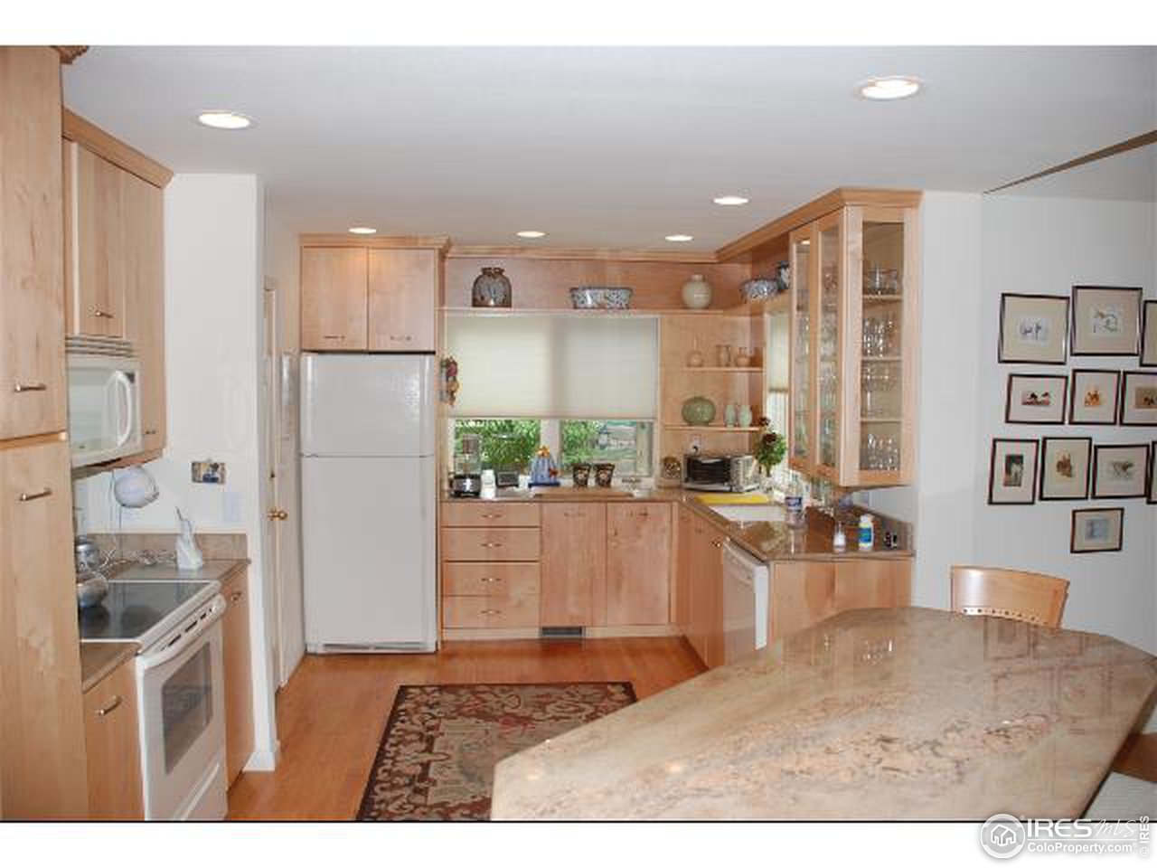 7233 Four Rivers Road Boulder, CO 80301 - Photo 3 of 12 a kitchen with stainless steel appliances granite countertop a refrigerator a sink a stove and white cabinets