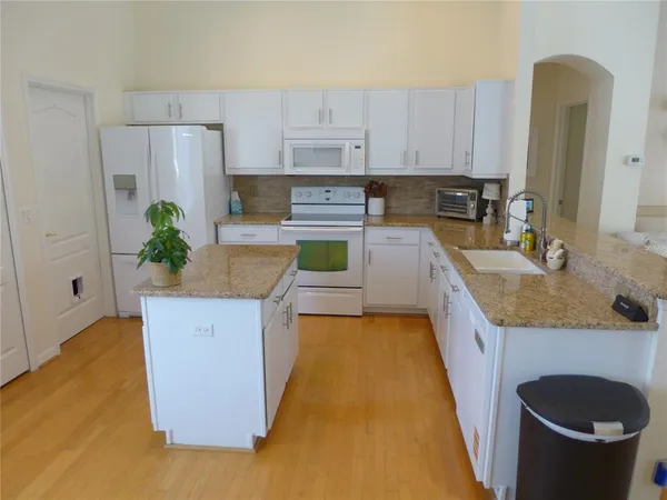 a kitchen with granite countertop a sink and a stove top oven