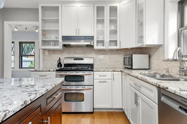 a kitchen with granite countertop cabinets stainless steel appliances and a sink