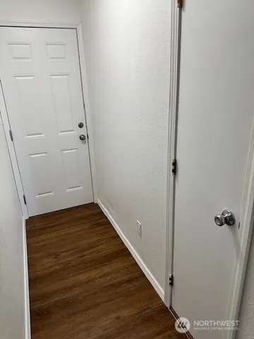 a view of a hallway with wooden floor
