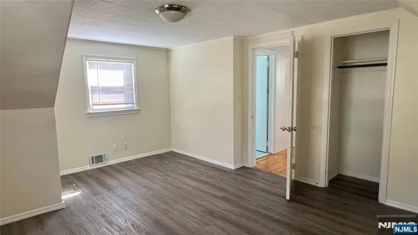 an empty room with wooden floor and a window