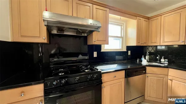 a kitchen with granite countertop white cabinets and black appliances