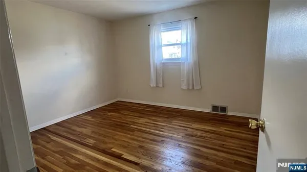 a view of a room with wooden floor and windows
