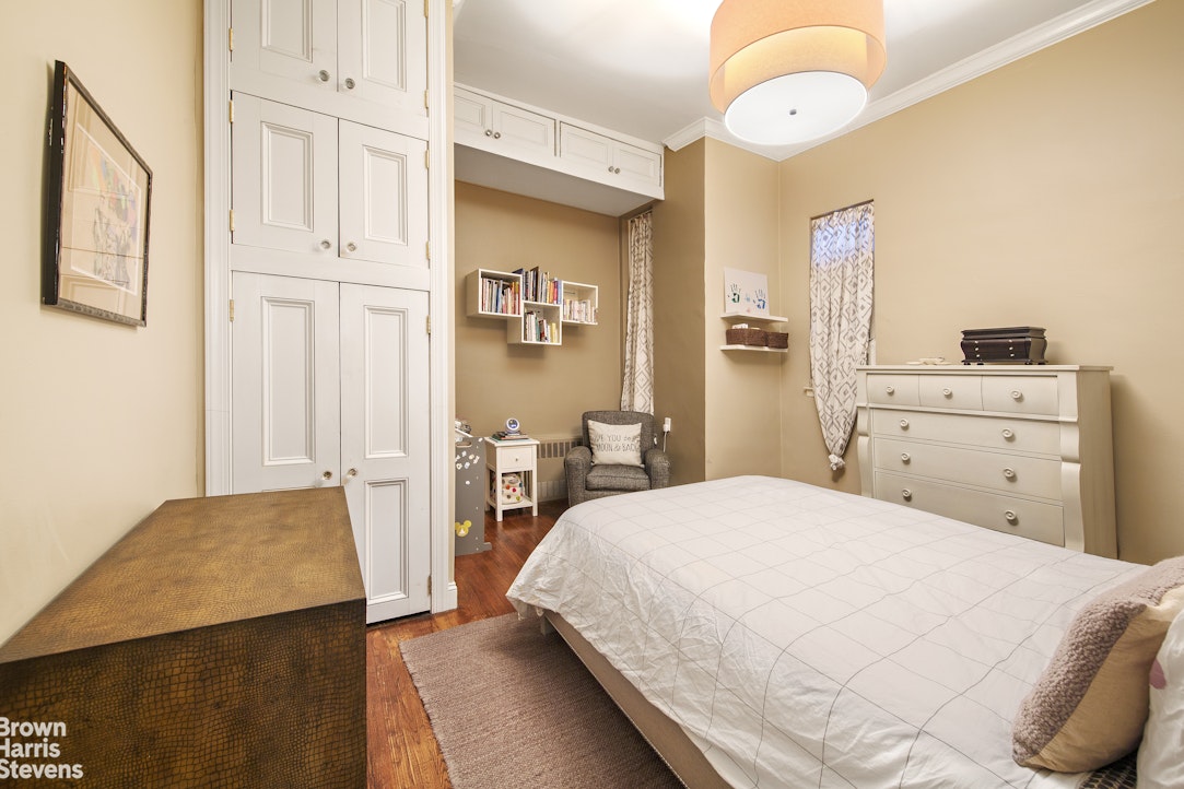 103 East 10th Street, Unit 3C Manhattan, NY 10003 - Photo 4 of 7 a bedroom with a bed and a chandelier