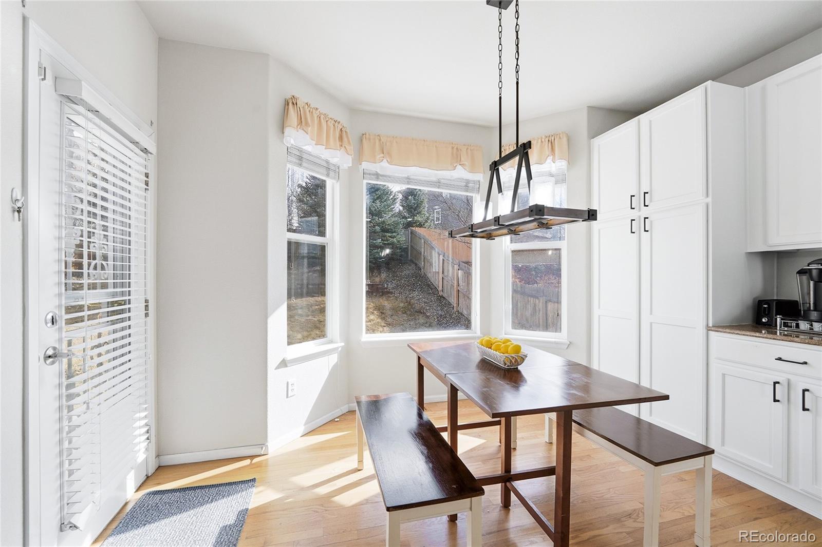 10468 Wagon Highlands Ranch Littleton, CO 80130 - Photo 11 of 48 a view of a dining room with furniture window and wooden floor