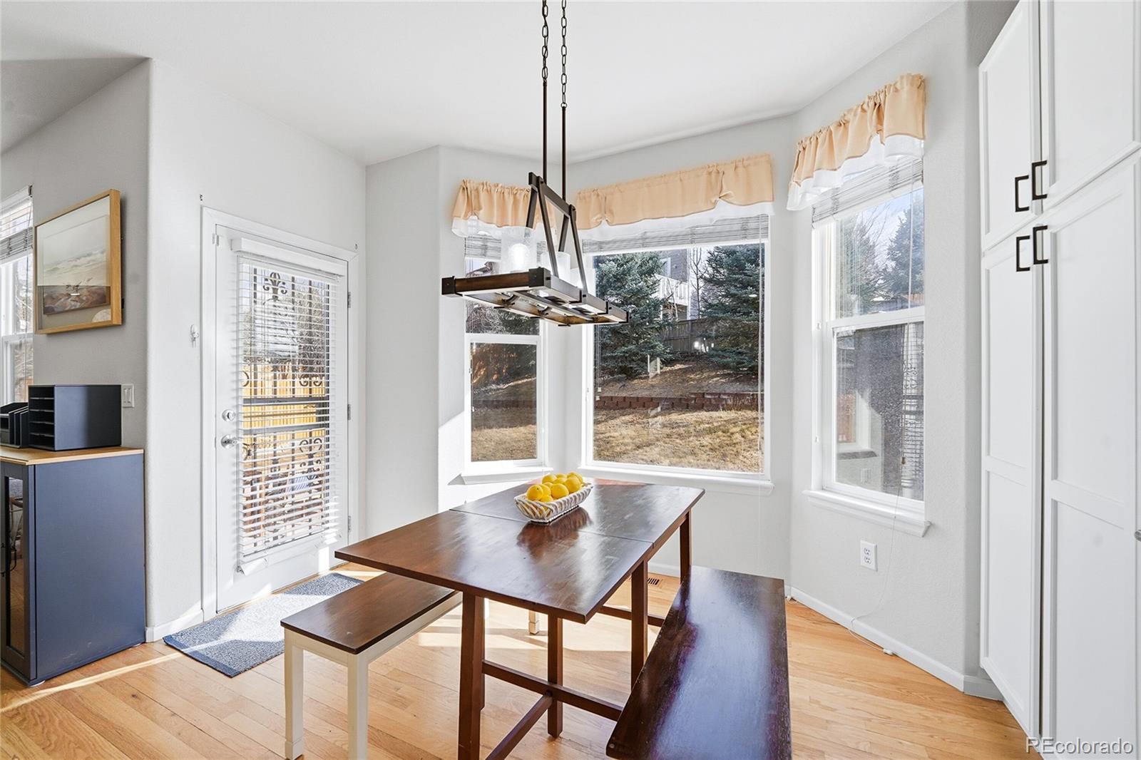 10468 Wagon Highlands Ranch Littleton, CO 80130 - Photo 12 of 48 a view of a dining room with furniture window and wooden floor