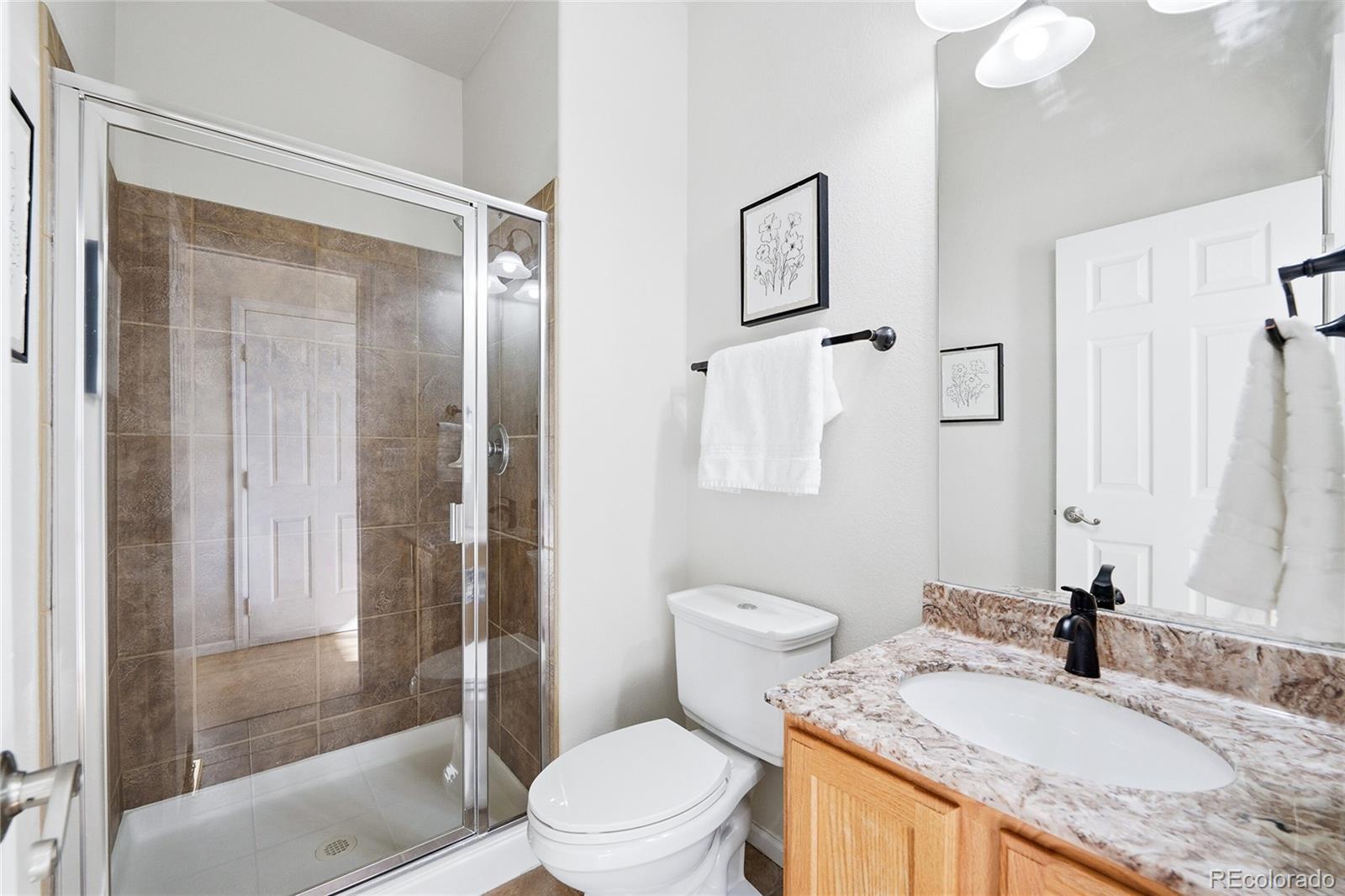 10468 Wagon Highlands Ranch Littleton, CO 80130 - Photo 19 of 48 a bathroom with a granite countertop sink toilet and shower