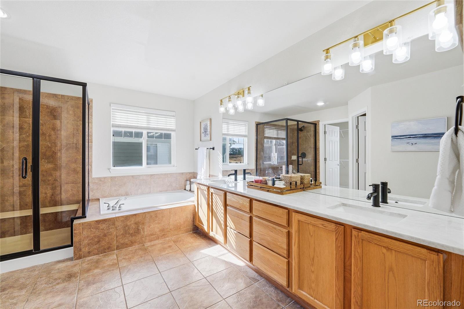 10468 Wagon Highlands Ranch Littleton, CO 80130 - Photo 22 of 48 a large bathroom with a large tub sink and glass door