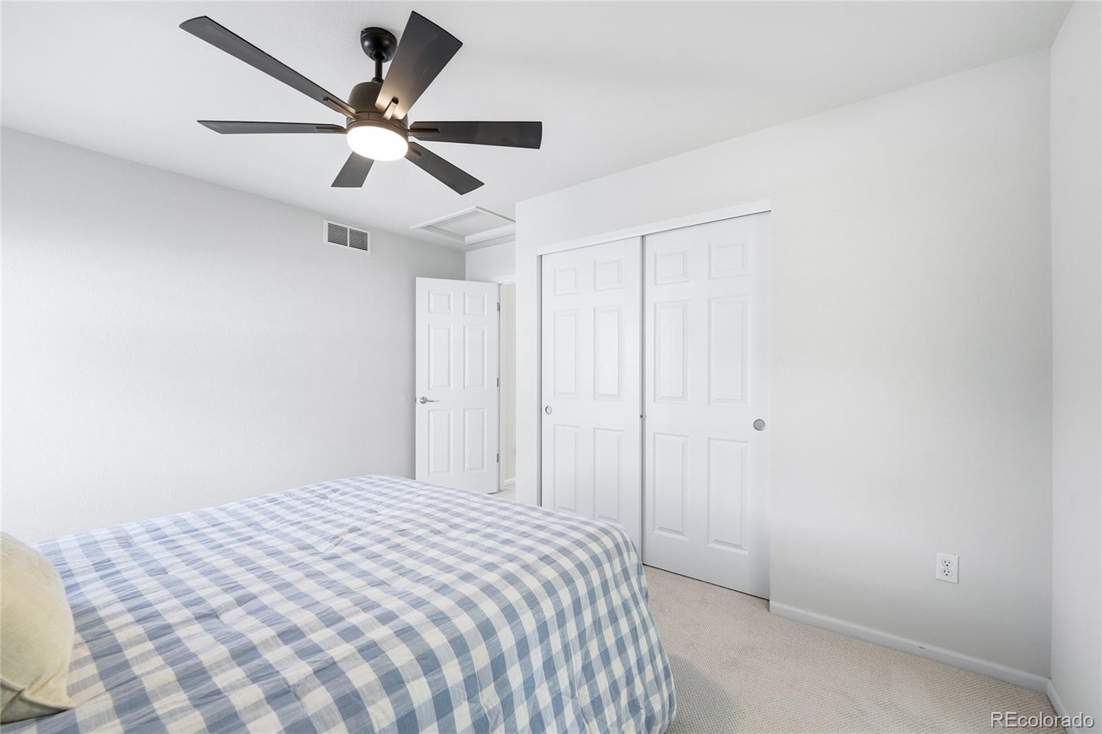 10468 Wagon Highlands Ranch Littleton, CO 80130 - Photo 26 of 48 a bedroom with a large bed and a ceiling fan