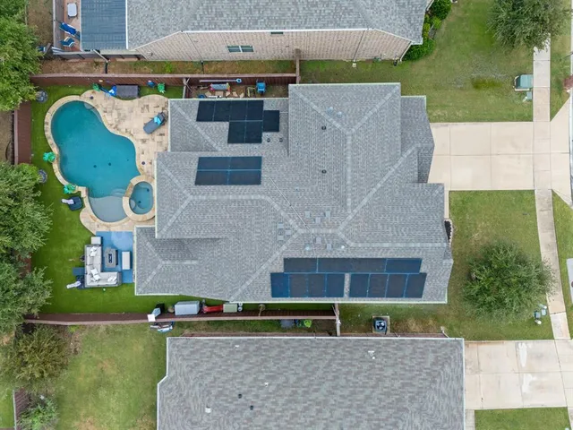 an aerial view of a house with a swimming pool and a yard