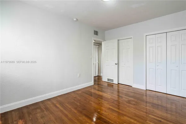 a view of an empty room with wooden floor