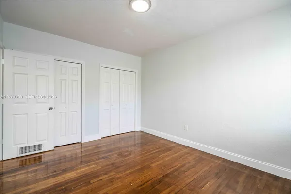 a view of an empty room with wooden floor