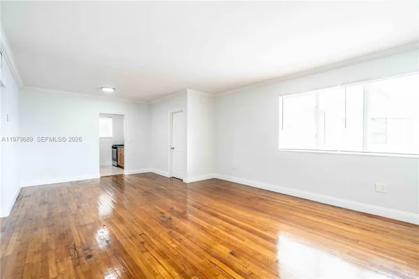 a view of empty room with wooden floor