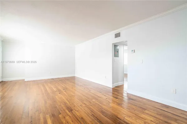 a view of an empty room with wooden floor
