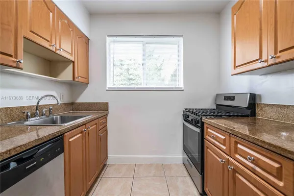 a kitchen with stainless steel appliances granite countertop a sink stove and cabinets