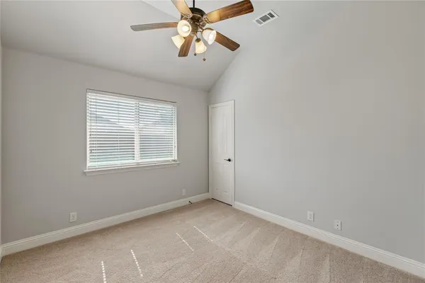 an empty room with a chandelier fan