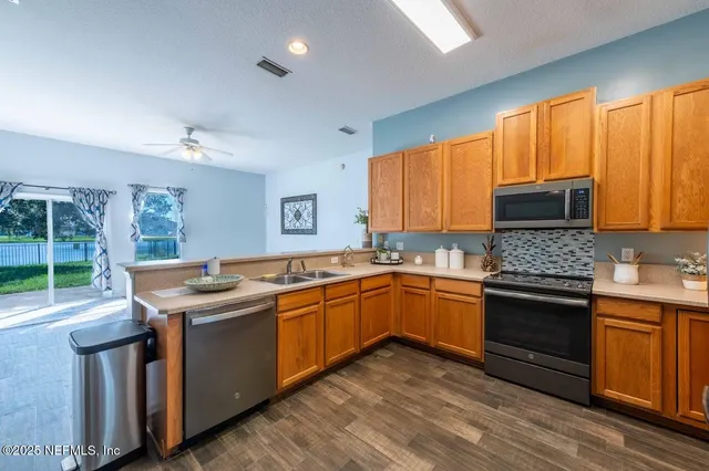 a kitchen with stainless steel appliances granite countertop wooden cabinets and a stove