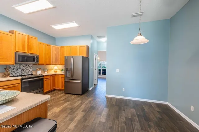 a kitchen with a refrigerator and a stove top oven