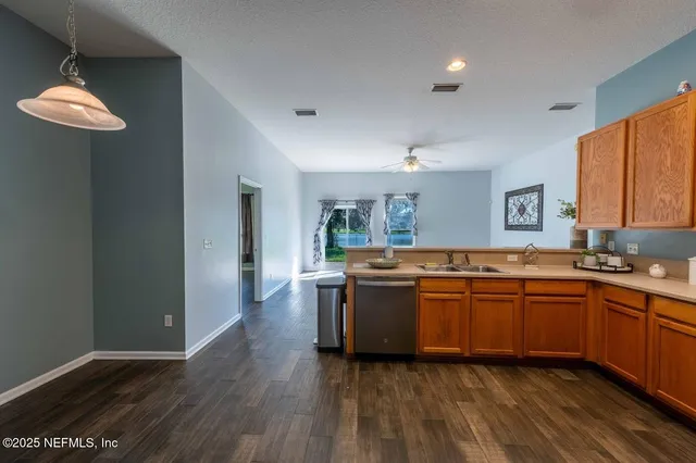 a large kitchen with stainless steel appliances granite countertop a stove and a wooden floors