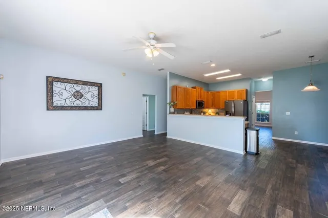 a view of a big room with wooden floor and windows