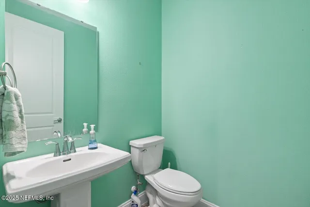 a bathroom with a sink a toilet and mirror