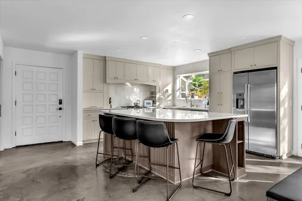 a kitchen with a table chairs refrigerator and cabinets