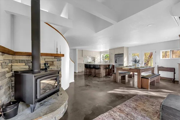 a living room with furniture a fireplace and a dining table with wooden floor