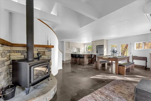 a living room with furniture a fireplace and a dining table with wooden floor