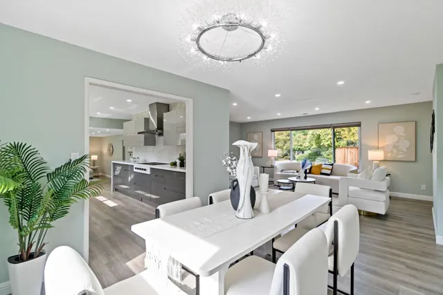 a large kitchen with stainless steel appliances a large counter top a stove a chimney a sink and a refrigerator