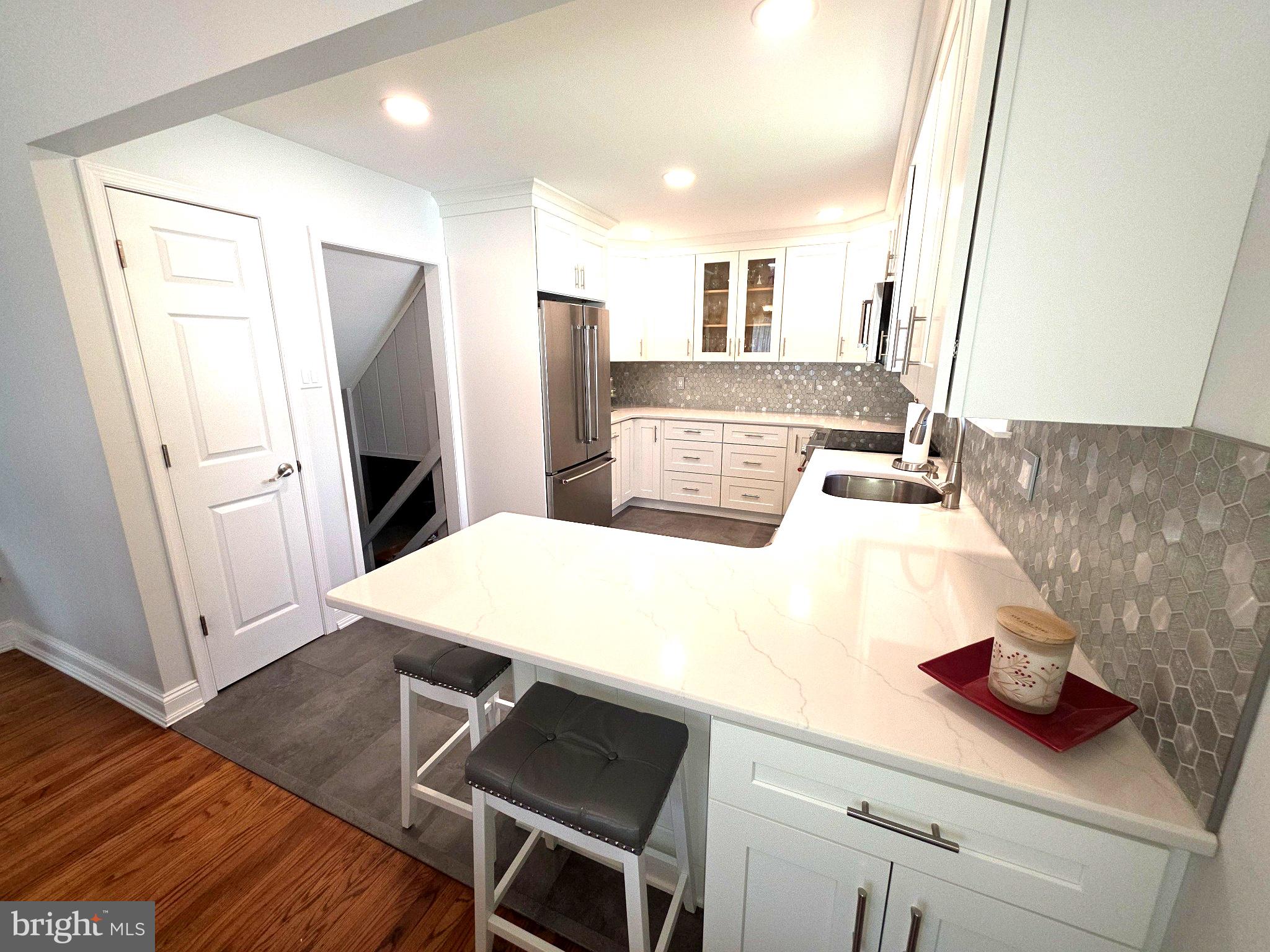156 Crockett Road Warminster, PA 18974 - Photo 19 of 57 a kitchen with stainless steel appliances a refrigerator a sink a stove and white cabinets with wooden floor
