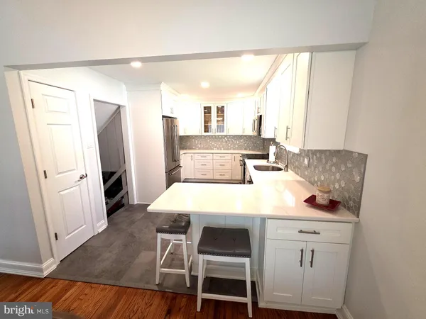 a kitchen with a stove a sink a microwave a dining table and chairs