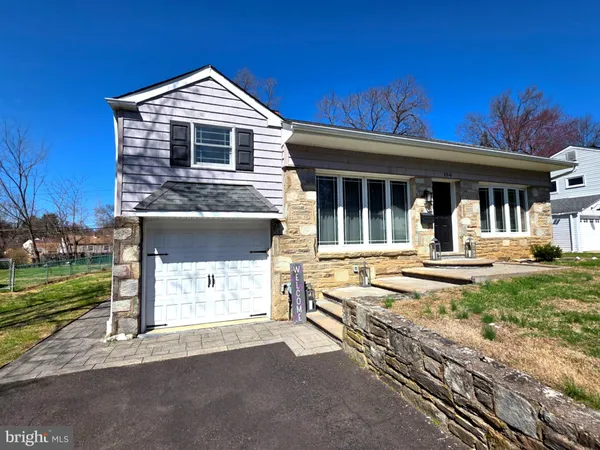 a front view of a house with a yard outdoor seating and garage