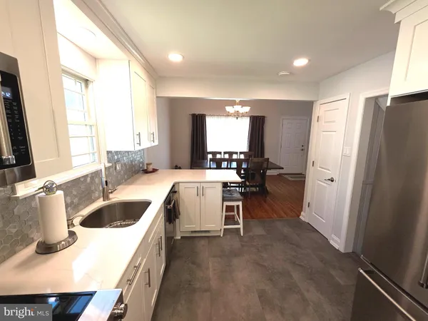 a kitchen with granite countertop white cabinets and white appliances