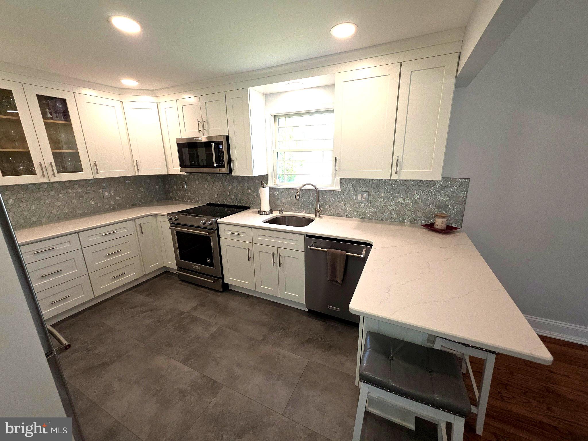 156 Crockett Road Warminster, PA 18974 - Photo 23 of 57 a kitchen with a stove a sink a microwave a dining table and chairs