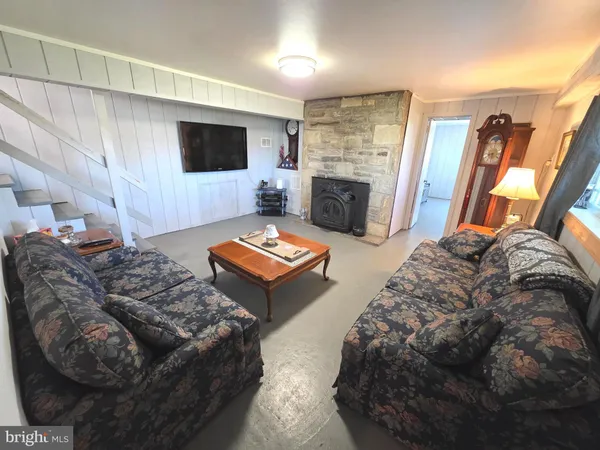 a living room with closet and a refrigerator