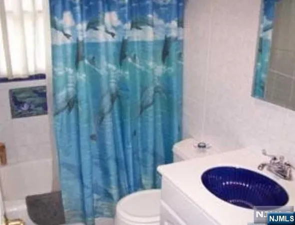 a bathroom with a sink a toilet and shower curtain