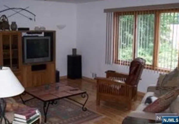 a living room with furniture a flat screen tv and a floor to ceiling window