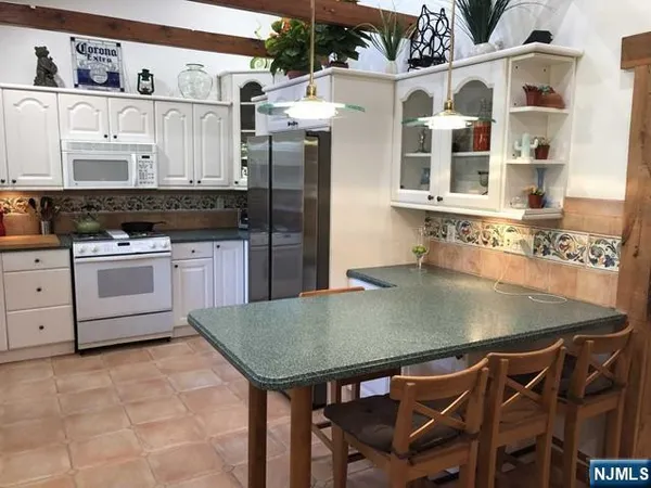 a kitchen with stainless steel appliances granite countertop a stove a refrigerator and a cabinets