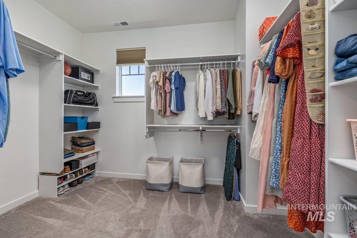 1380 West Chilitna Street Meridian, ID 83642 - Photo 30 of 50 Spacious walk-in closet featuring built-in shelving, multiple hanging rods, and plush carpet flooring